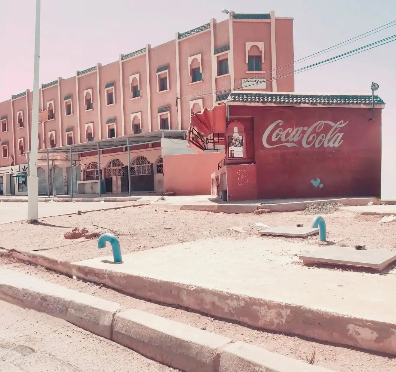 Edificio rosa con murales Coca-Cola in una cittadina del sud del Marocco